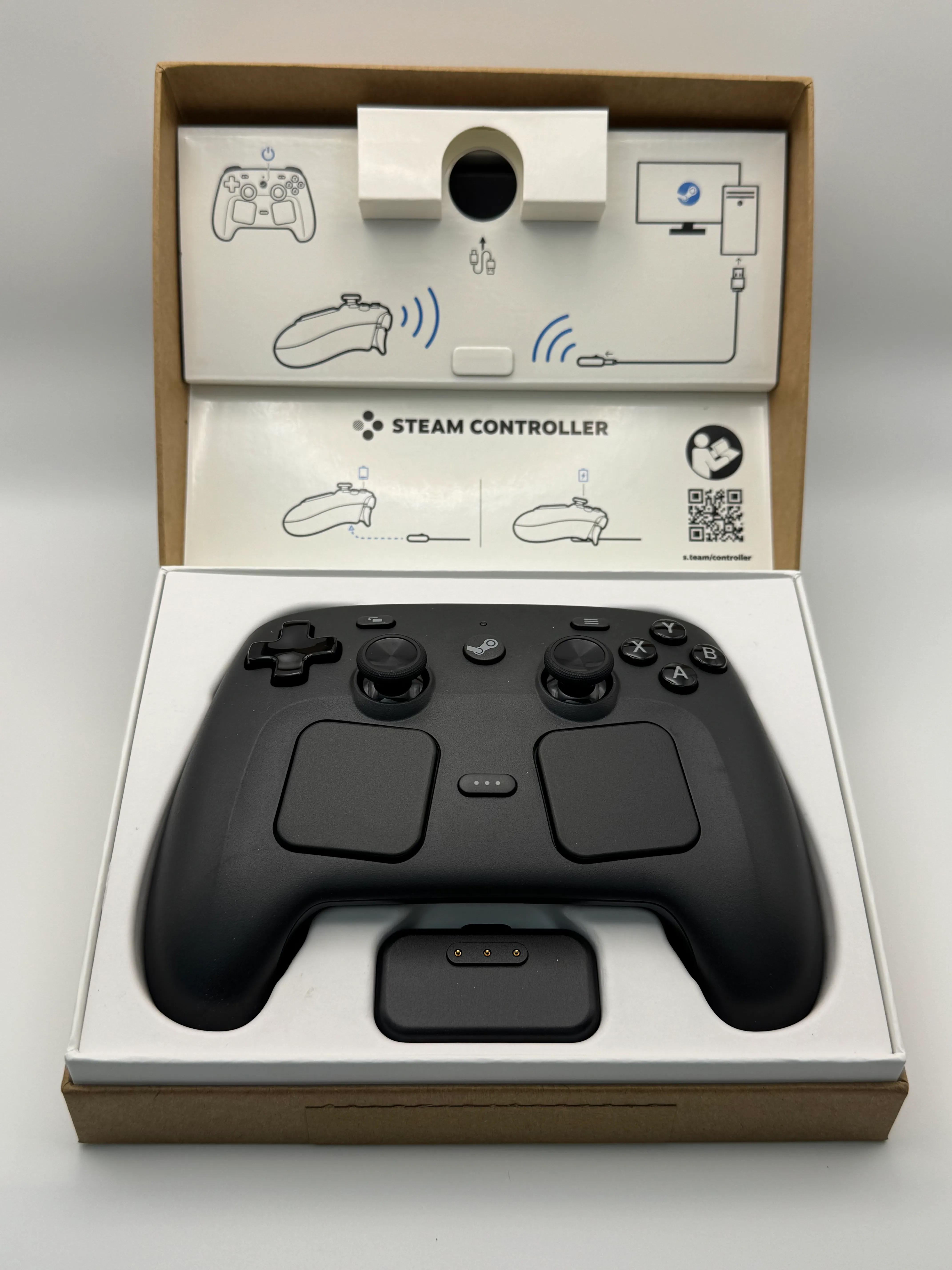 The box opened showing the controller, charging puck, and inner packaging