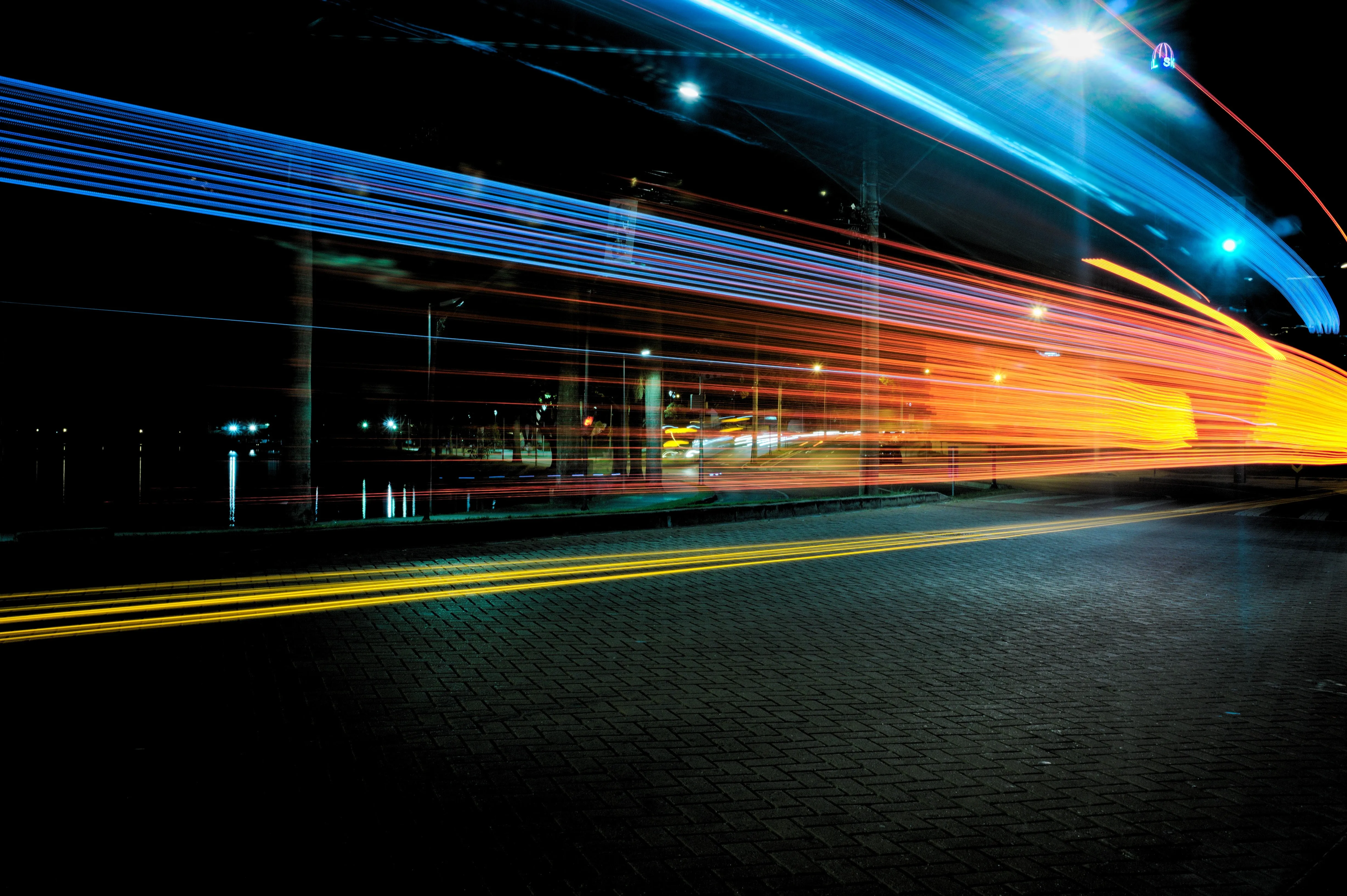 Long exposure shot of vehicle lights passing by on a dark street